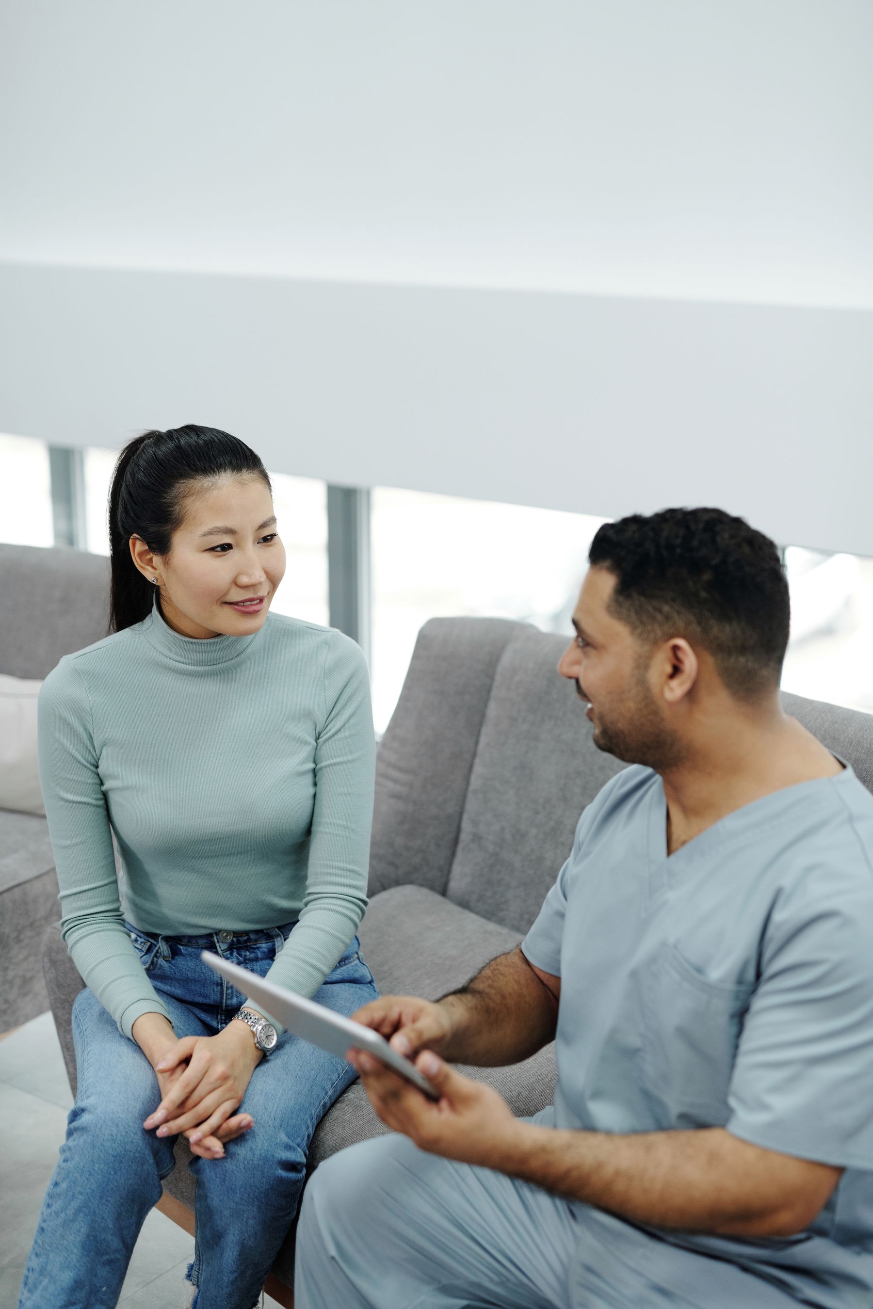Clinician using a tablet while speaking with a patient